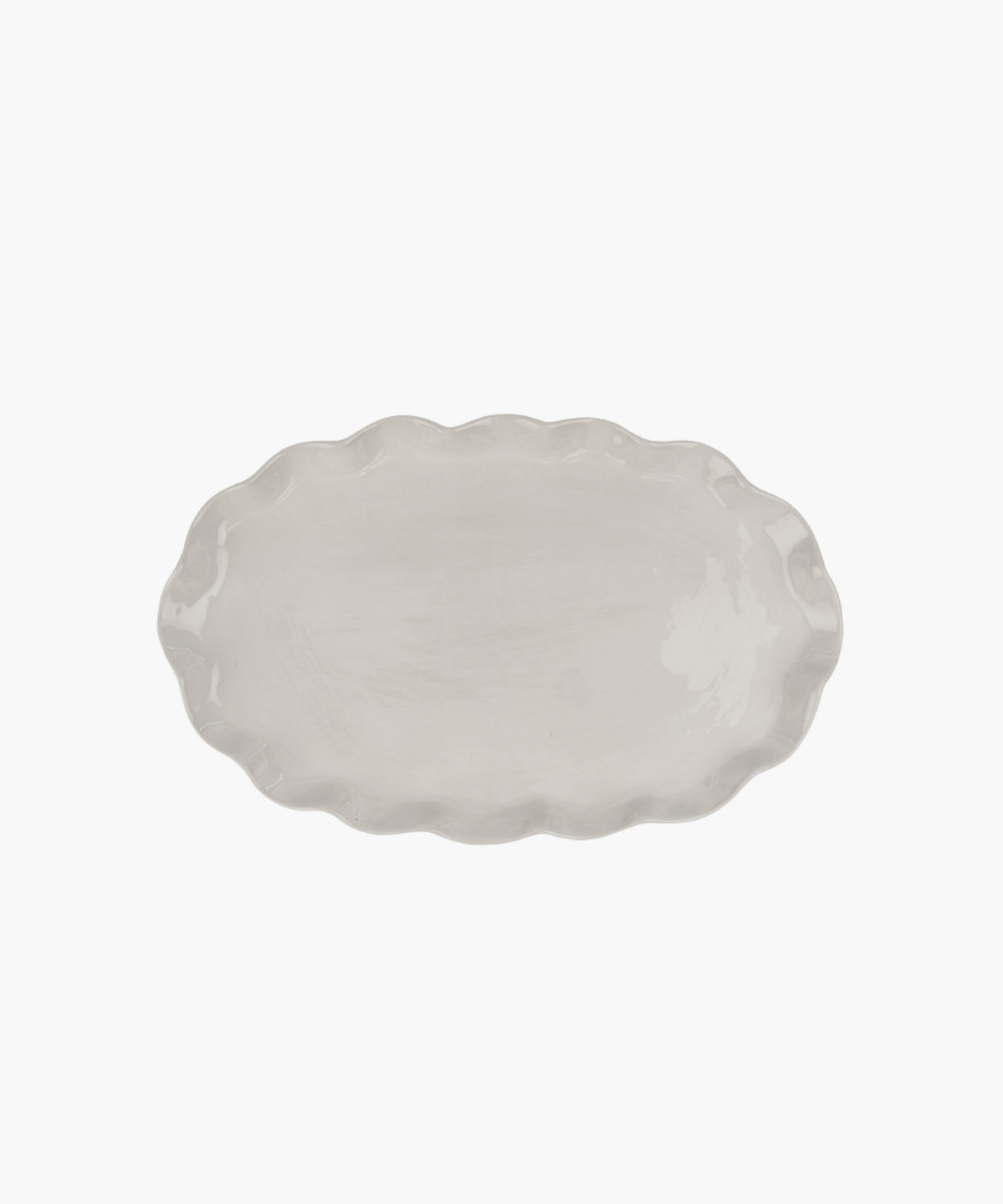 An oval, ceramic platter with a wavy, scalloped edge in a light cream color. The minimalist design conveys simplicity and elegance.
