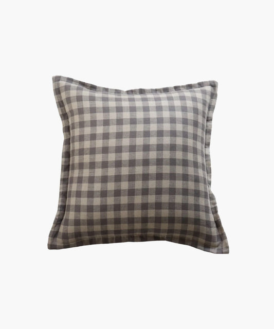 A square pillow cover features a blue gray gingham pattern on a natural fabric printed on both sides conveying a cozy and rustic feel.