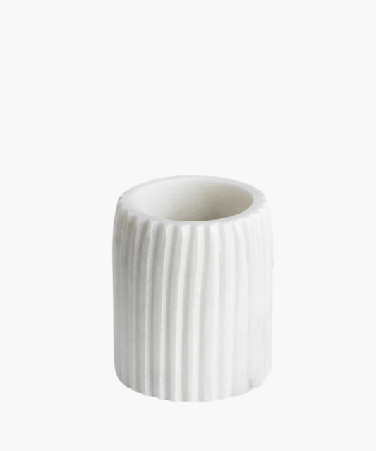 White cylindrical marble tumbler with vertical ridges stands on a white background. The tumbler is simplistic and elegant, exuding a modern, minimalistic vibe.