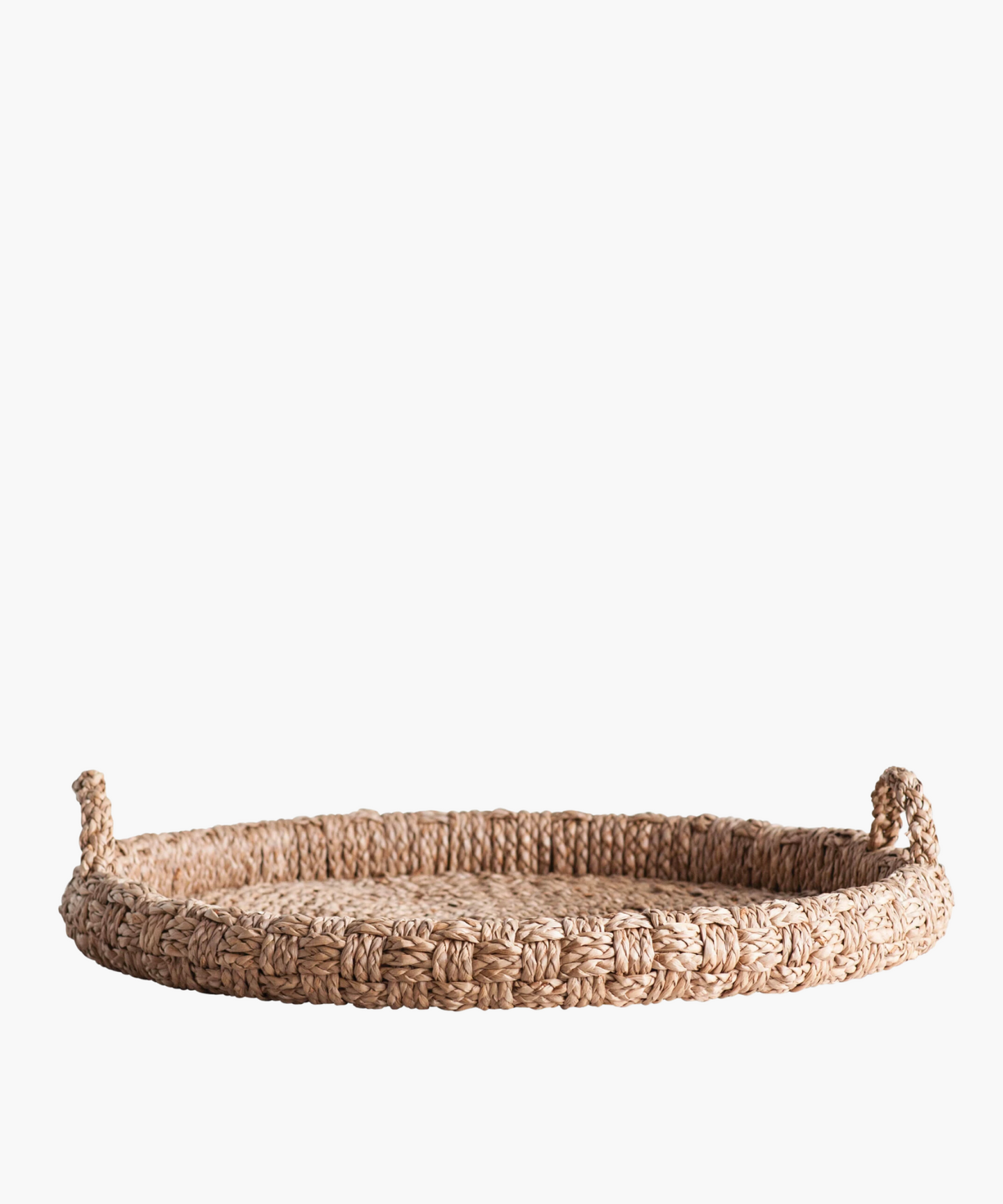 Round braided wicker tray or basket with two looped handles. The natural fibers create a warm, rustic feel. The basket's texture is tightly knit and sturdy.