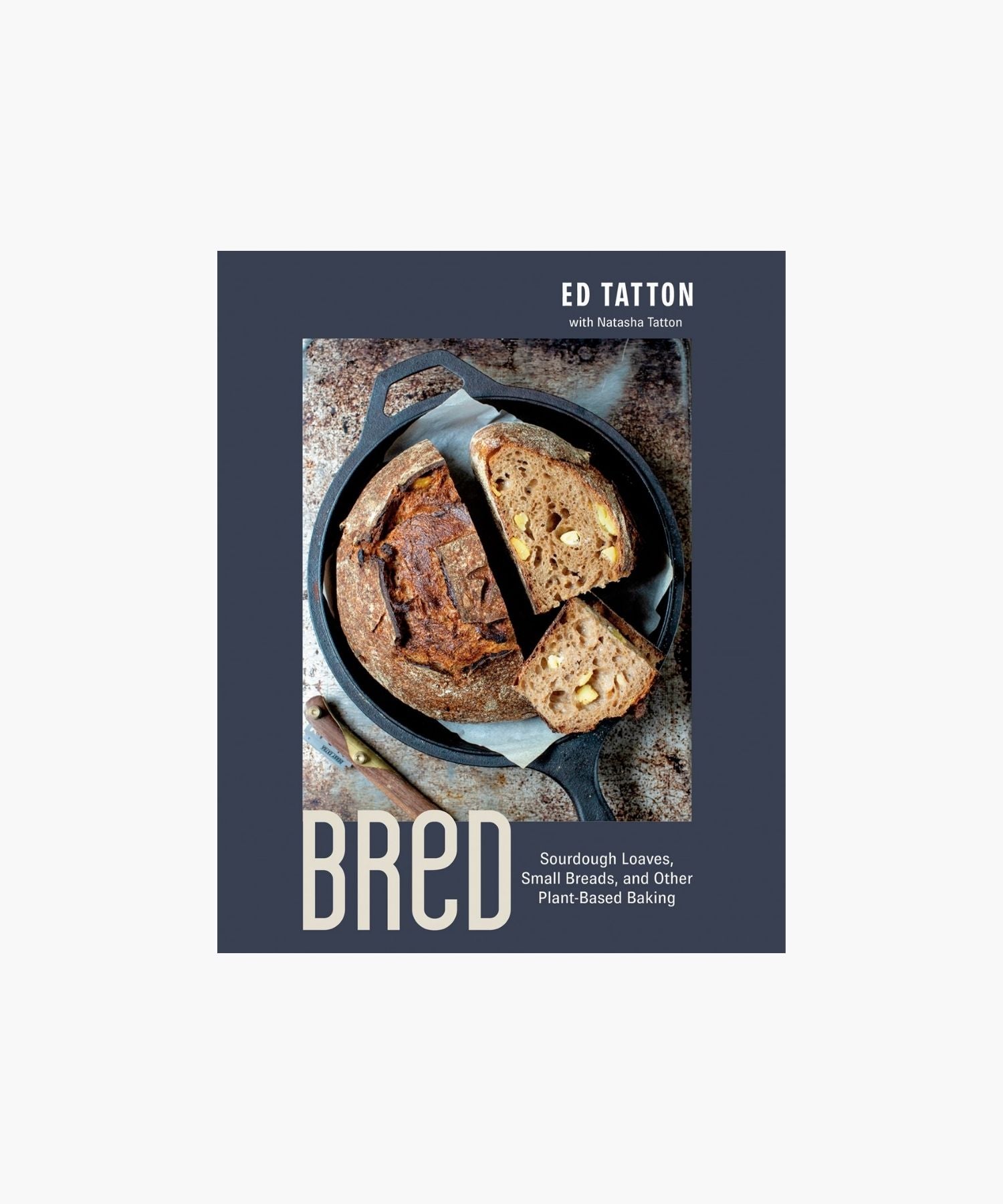 Cookbook cover titled "Bred: Sourdough Loaves, Small Breads, and other Plant-Based Baking" by Ed Tatton features a sliced, rustic loaf in a cast iron pan on a textured surface, conveying a cozy, artisanal feel.