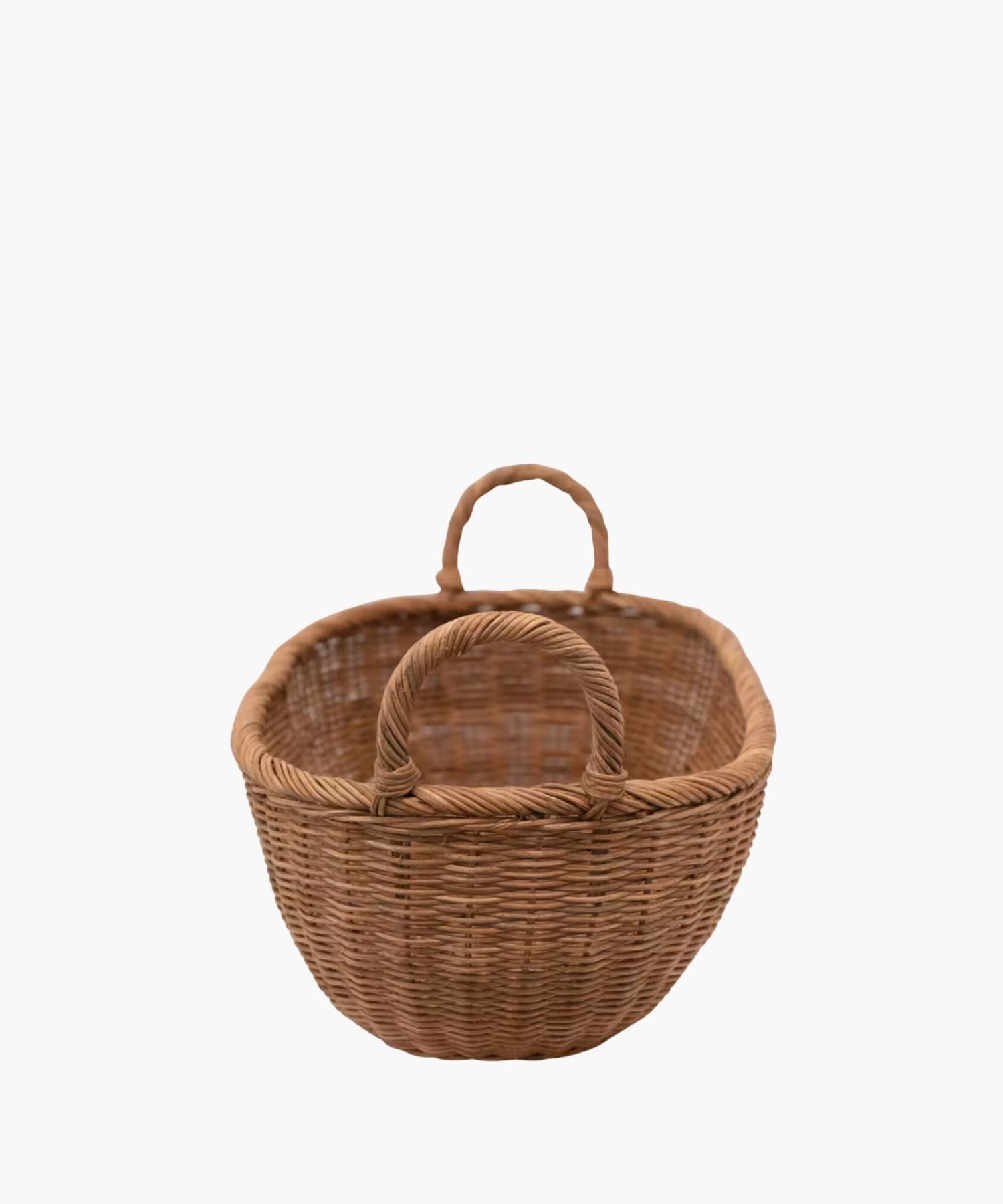 Side profile of a handwoven wicker basket with two looped handles on either side featuring an organic oval shape and a natural brown finish. The basket has a natural, rustic appearance.