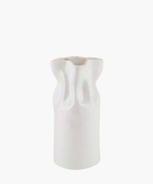 A glossy white ceramic vase with an abstract, textured surface resembling flowing fabric. The vase has a tall, cylindrical shape with a flared, uneven rim.