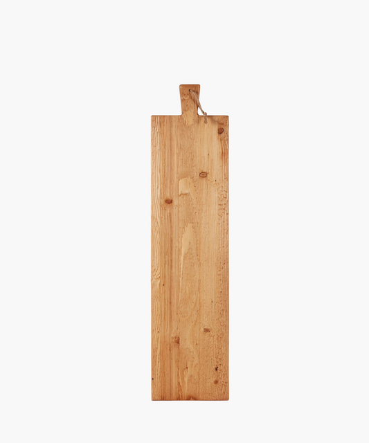 A long, rectangular hand-crafted wooden cutting board with a natural finish and visible grains from reclaimed wood. It has a small, integrated handle with a loop at the top for hanging.