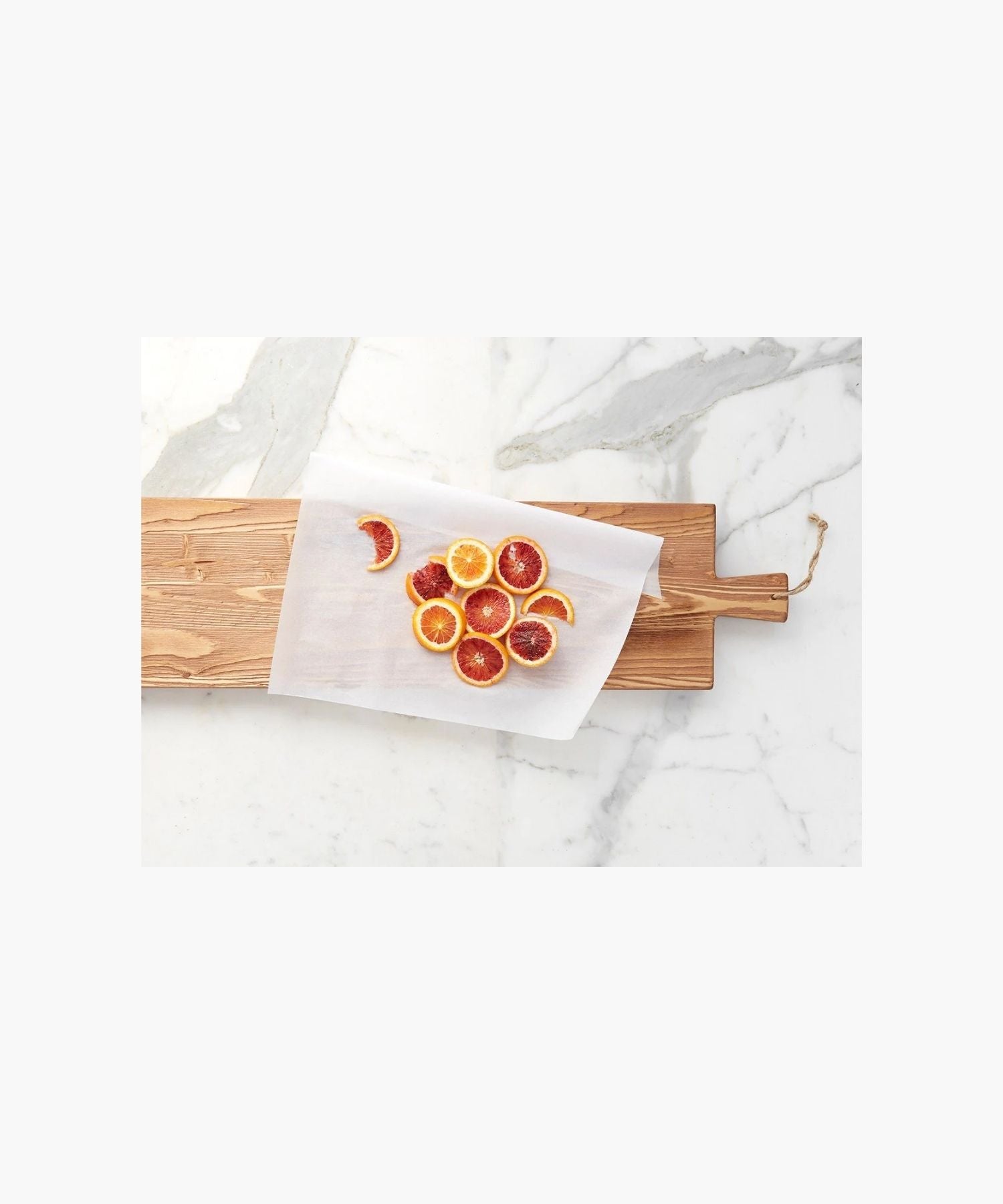 A long, rectangular hand-crafted wooden cutting board with a natural finish and visible grains from reclaimed wood styled with sliced oranges. 