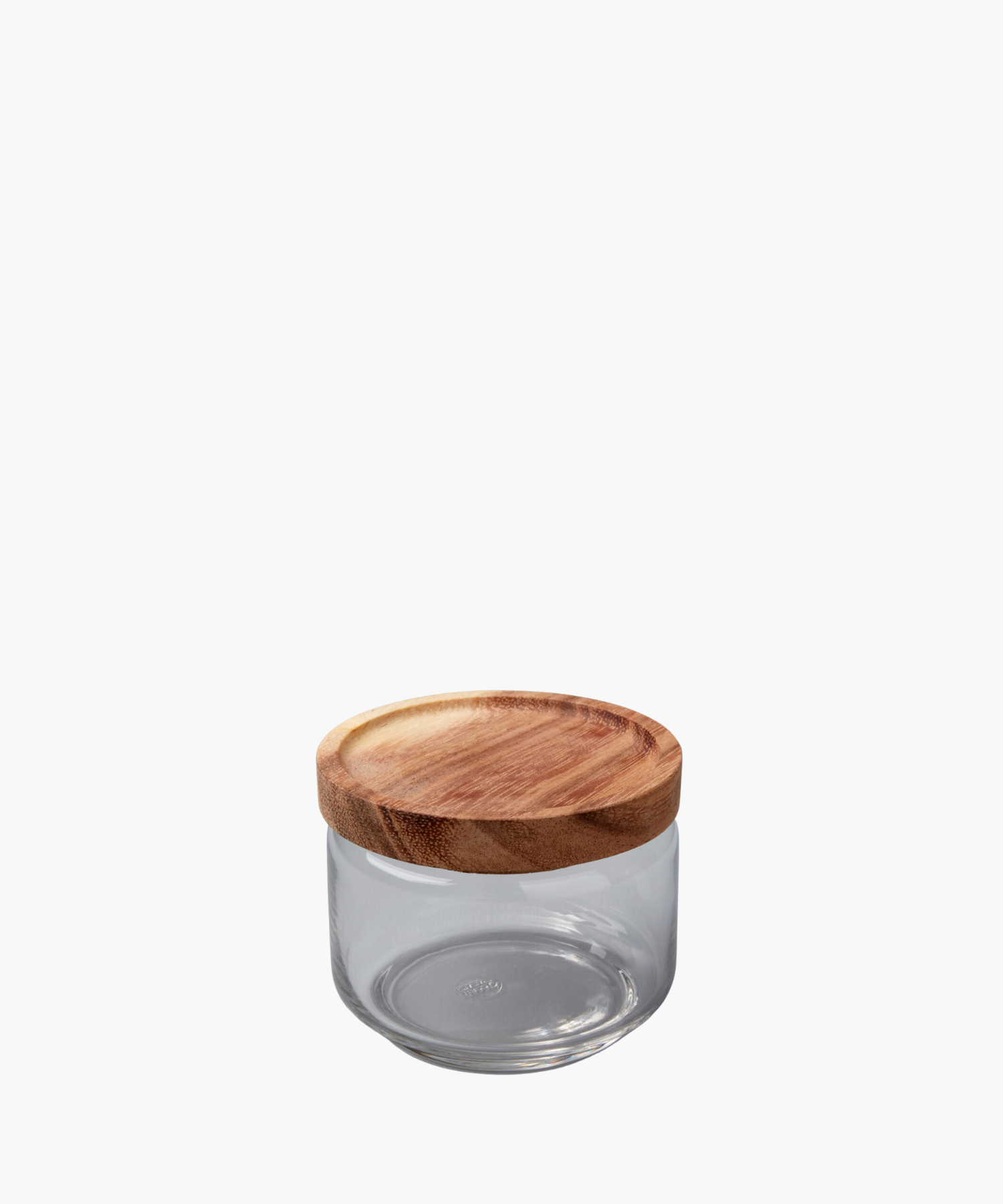 A clear glass jar with a round, smooth wooden lid sits against a white background. The simple, functional design conveys a minimalist aesthetic.