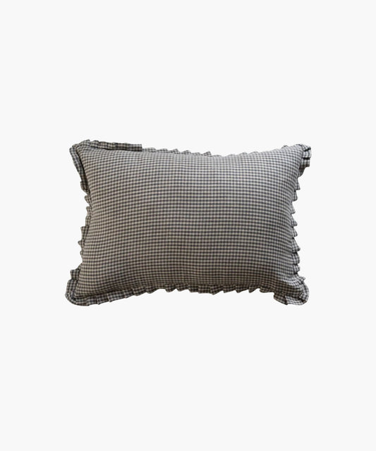 A rectangular lumbar pillow with a black and white gingham pattern and ruffled edges, conveying a classic and cozy feel, set against a plain background.