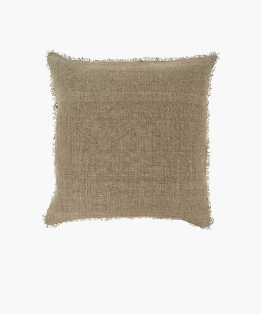 A square, beige pillow with a textured fabric and frayed edges, conveying a rustic, cozy feel. Set against a plain white background.