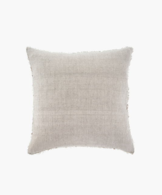 A beige linen throw pillow with a soft, textured surface and frayed edges, conveying a cozy and rustic feel, set against a white background.