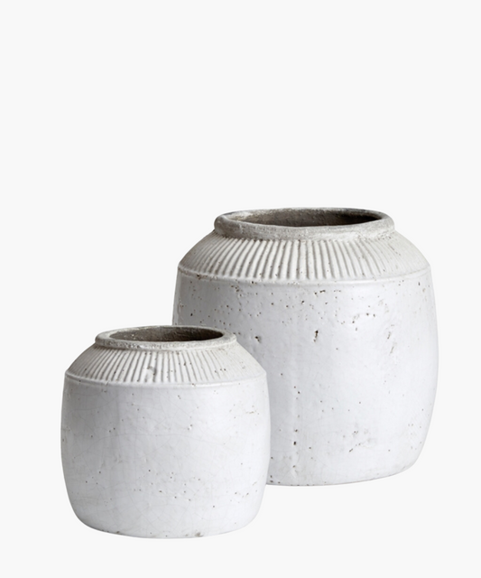 Textured white ceramic pots with a round body and a narrow opening in 2 sizes. The pots have subtle vertical ridges near the top.