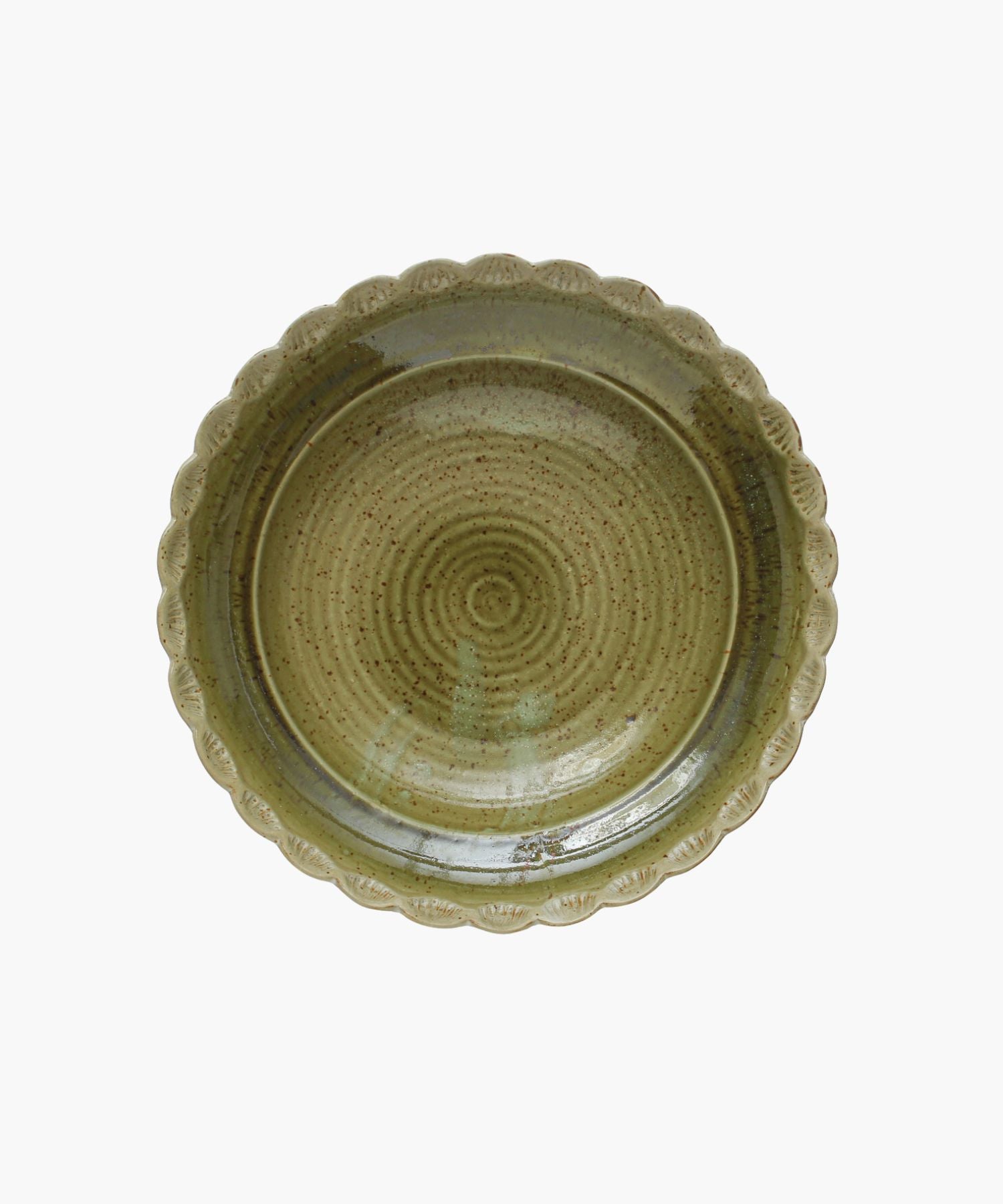 Overhead view of the Scandinavian-inspired stoneware bowl with a scalloped edge and a naturally variating reactive green glaze. The minimalist design gives an elegant and timeless appearance. 