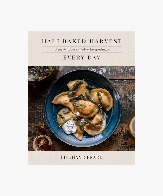 Cookbook cover titled "Half Baked Harvest Every Day" by Tieghan Gerard features a rustic, cozy image of ravioli with sage on a blue plate.