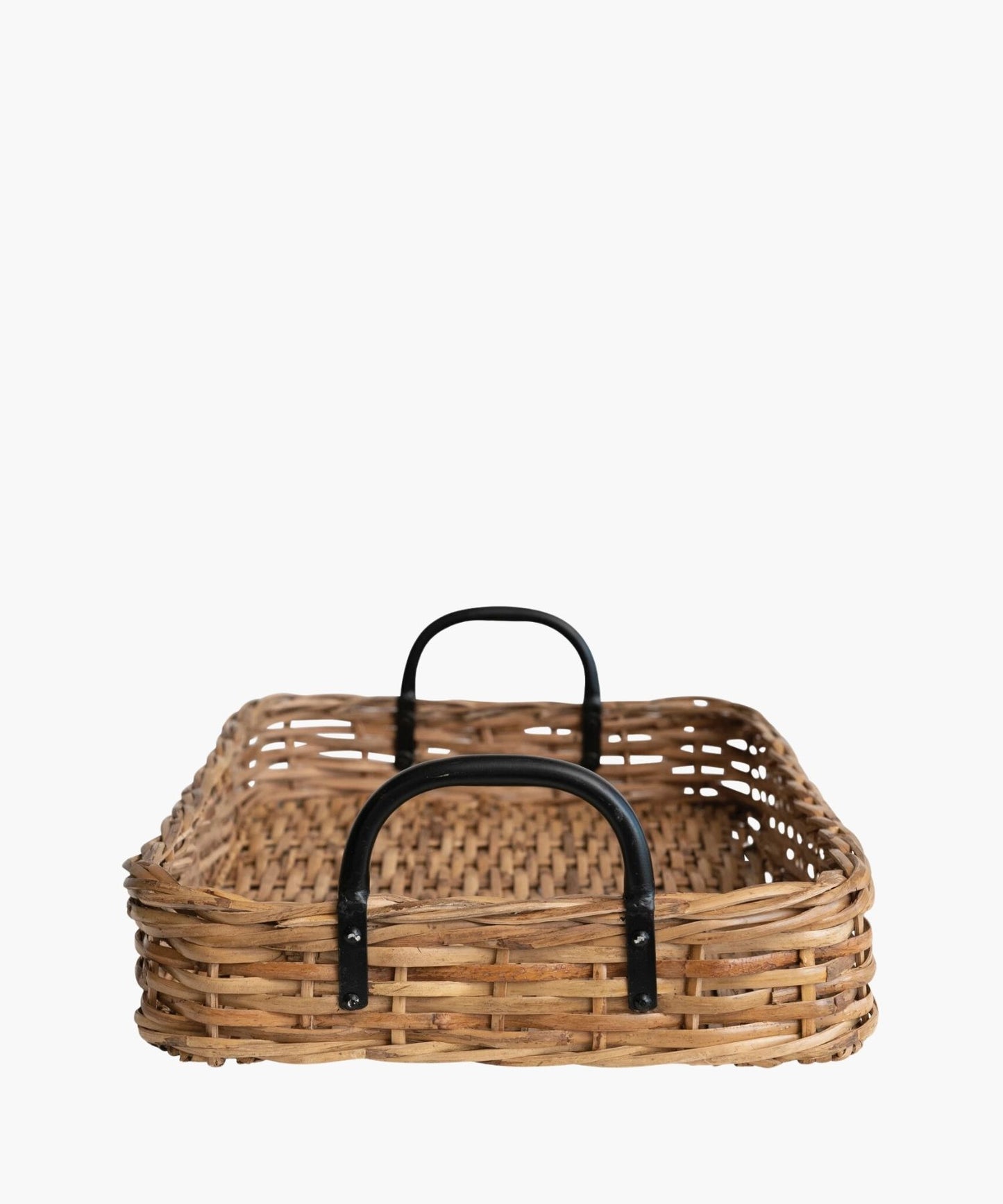 A rectangular woven rattan tray or basket with a natural brown finish features black metal handles on both ends. The style is rustic and earthy.