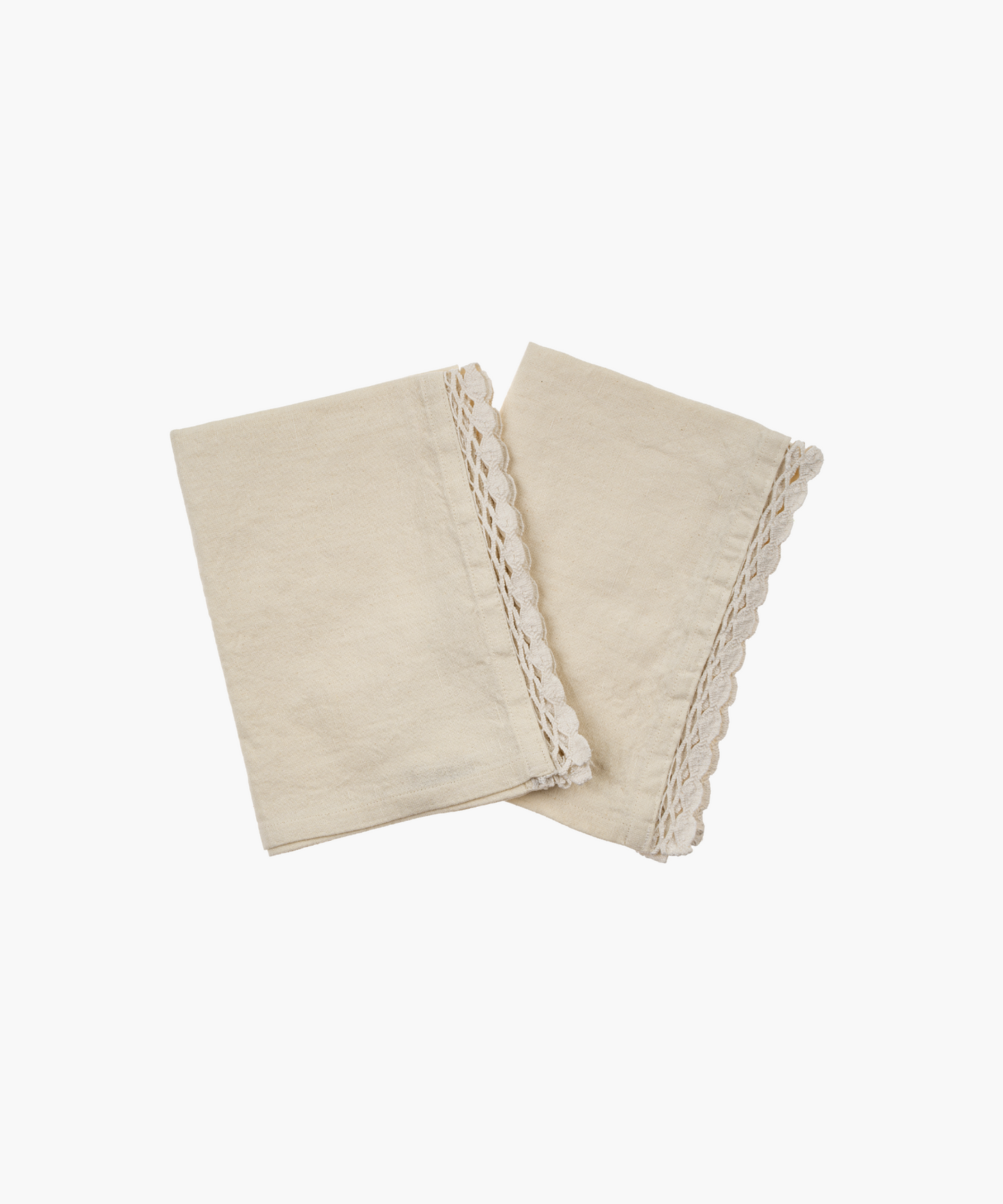 Two soft cotton linen napkins with scalloped lace edges, elegantly arranged and folded. They convey a rustic and cozy aesthetic.