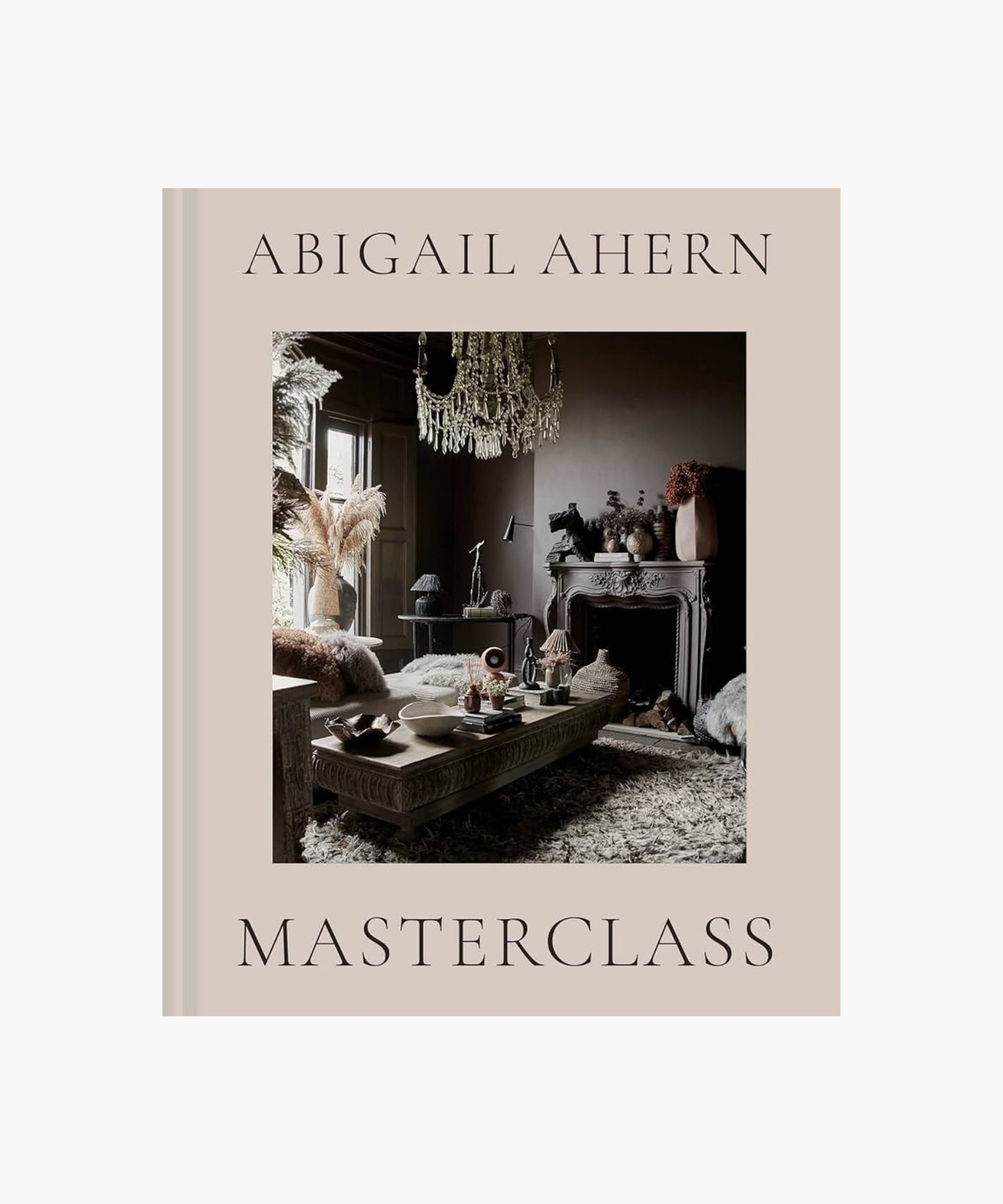 The cover of the book "Masterclass" by Abigail Ahern features an elegant room with moody decor, featuring a chandelier, ornate fireplace, and textured furnishings.