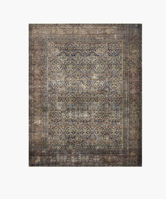 A vintage inspired rug with intricate floral and geometric patterns in muted blues, reds, and browns. It exudes a sense of classic elegance and warmth.