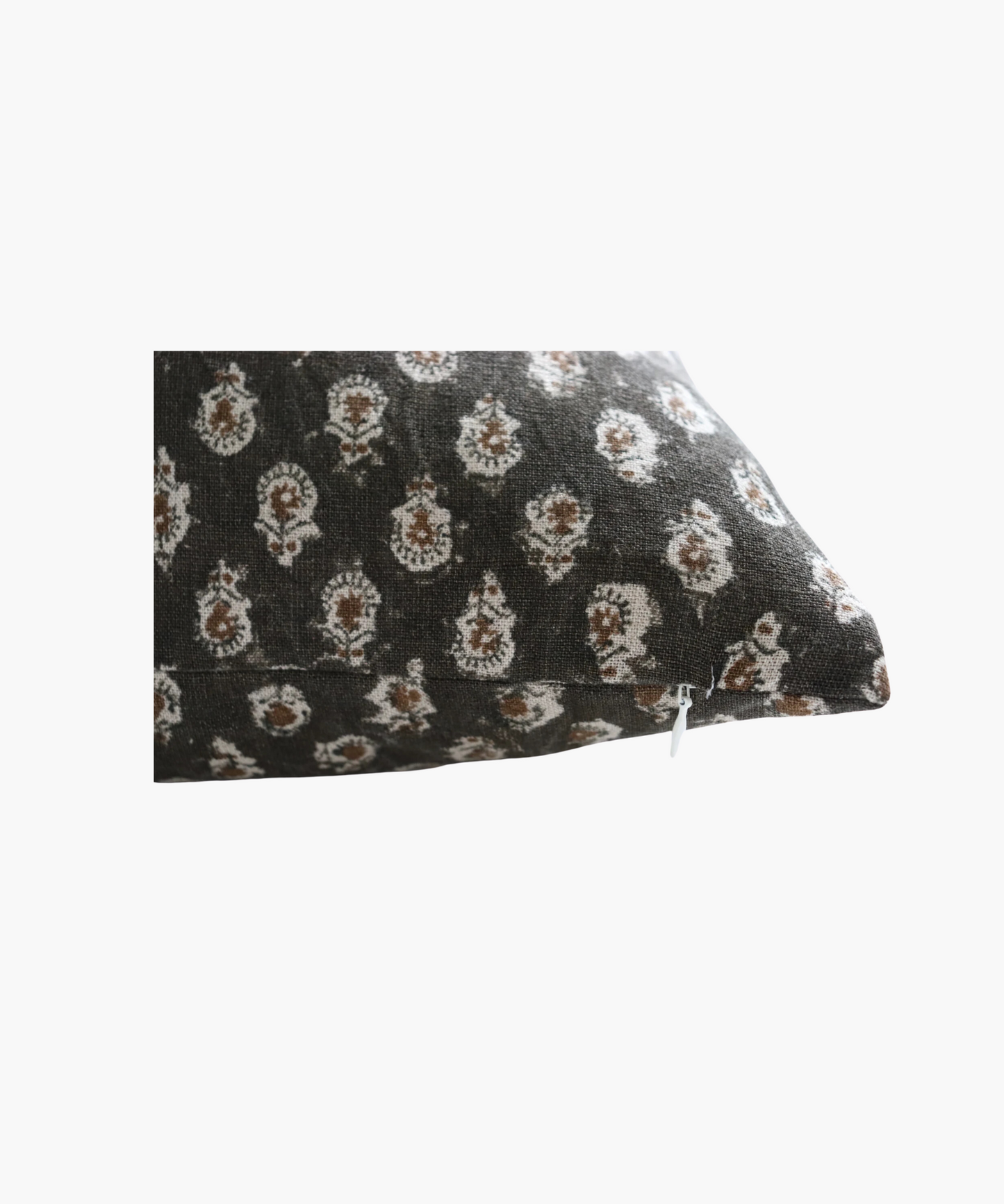 A detailed picture of a square pillow highlighting the dark brown background and a pattern of small, intricate white floral designs, conveying a cozy and elegant feel.