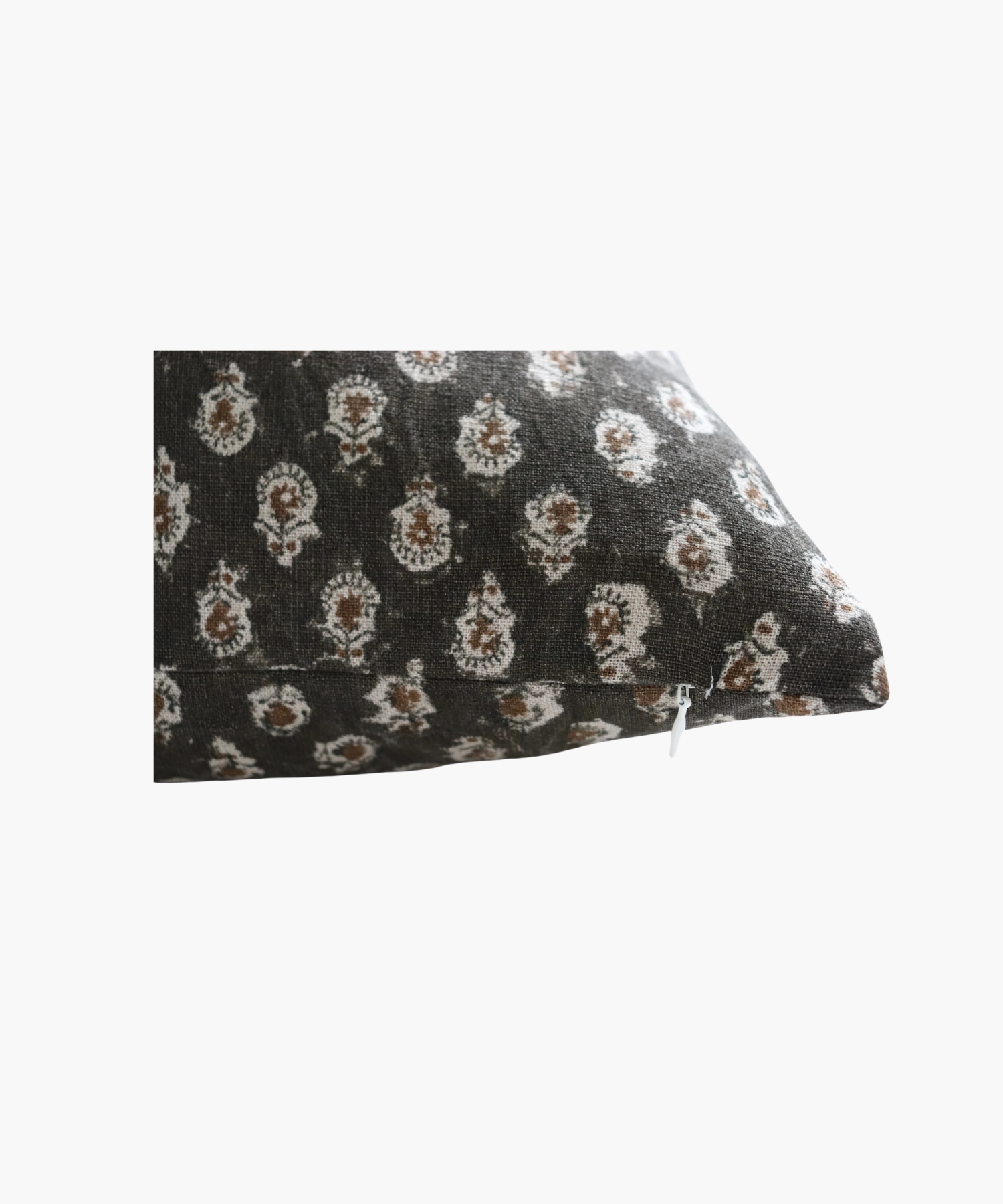 A detailed picture of a square pillow highlighting the dark brown background and a pattern of small, intricate white floral designs, conveying a cozy and elegant feel.