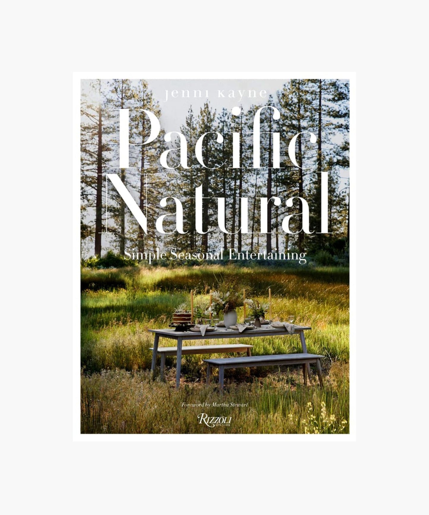 The cover of the book "Pacific Natural" by Jenni Kayne featuring a serene outdoor picnic scene with a rustic table set in a sunlit forest, conveying tranquility and elegance.