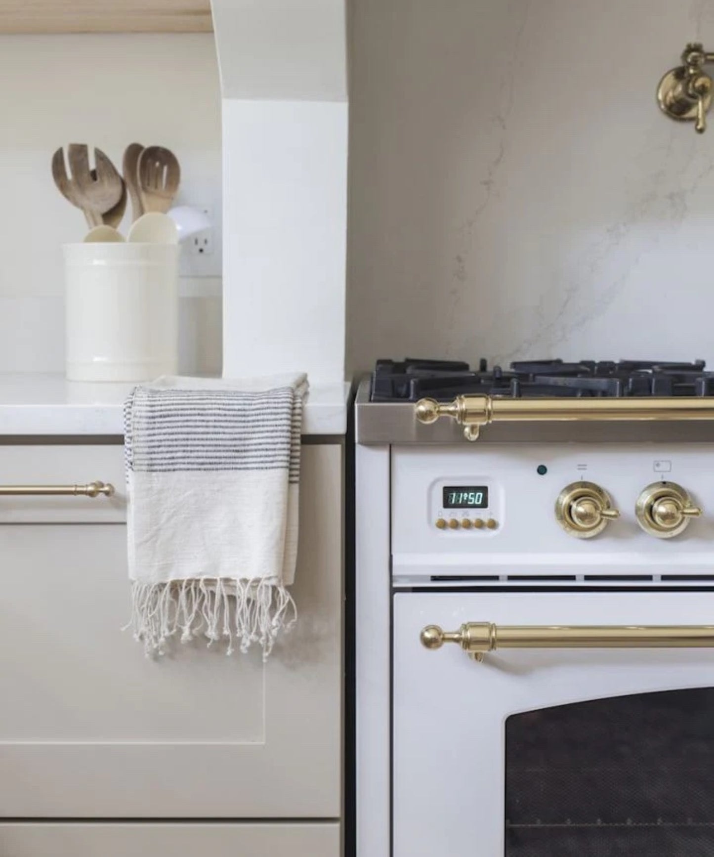 Hand-woven cotton hand towel accented with ribbed lines of color in navy blue styled on kitchen counter with a neutral palette. 