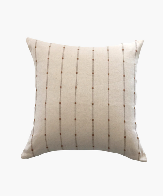 A beige square pillow with a minimalist pattern of thin, vertical brown lines and small dots, creating a calm and modern appearance.