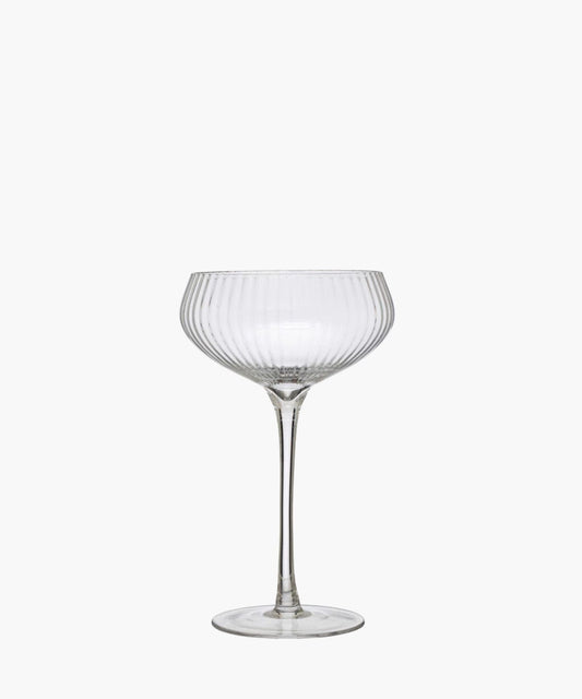 Elegant, clear glass coupe with vertical ridges, featuring a wide, shallow bowl and a tall stem. It exudes sophistication and vintage charm.