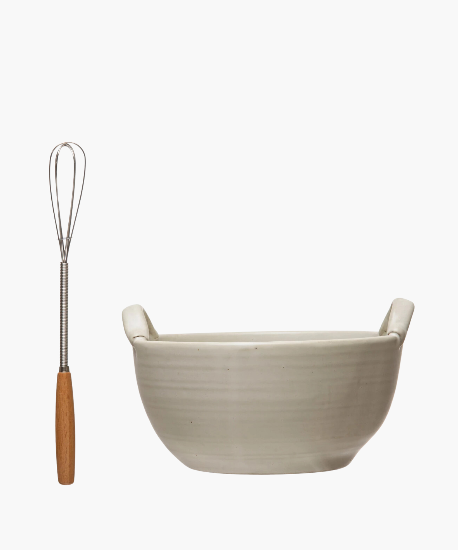 A cream colored stoneware ceramic mixing bowl with a metal whisk, evoking a clean, minimalist aesthetic.