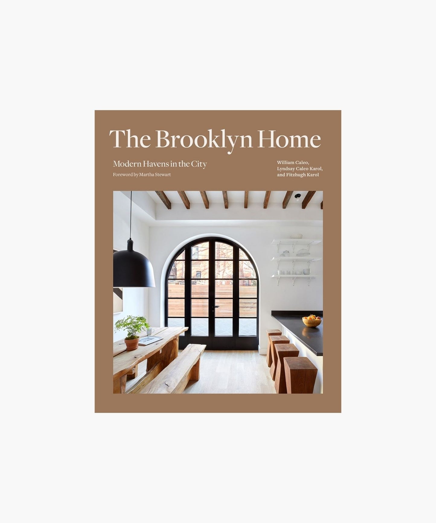 The cover of the book "The Brooklyn Home" shows a modern dining room with exposed beams, a large arched window, wooden furniture, and a plant. Minimalist and inviting.