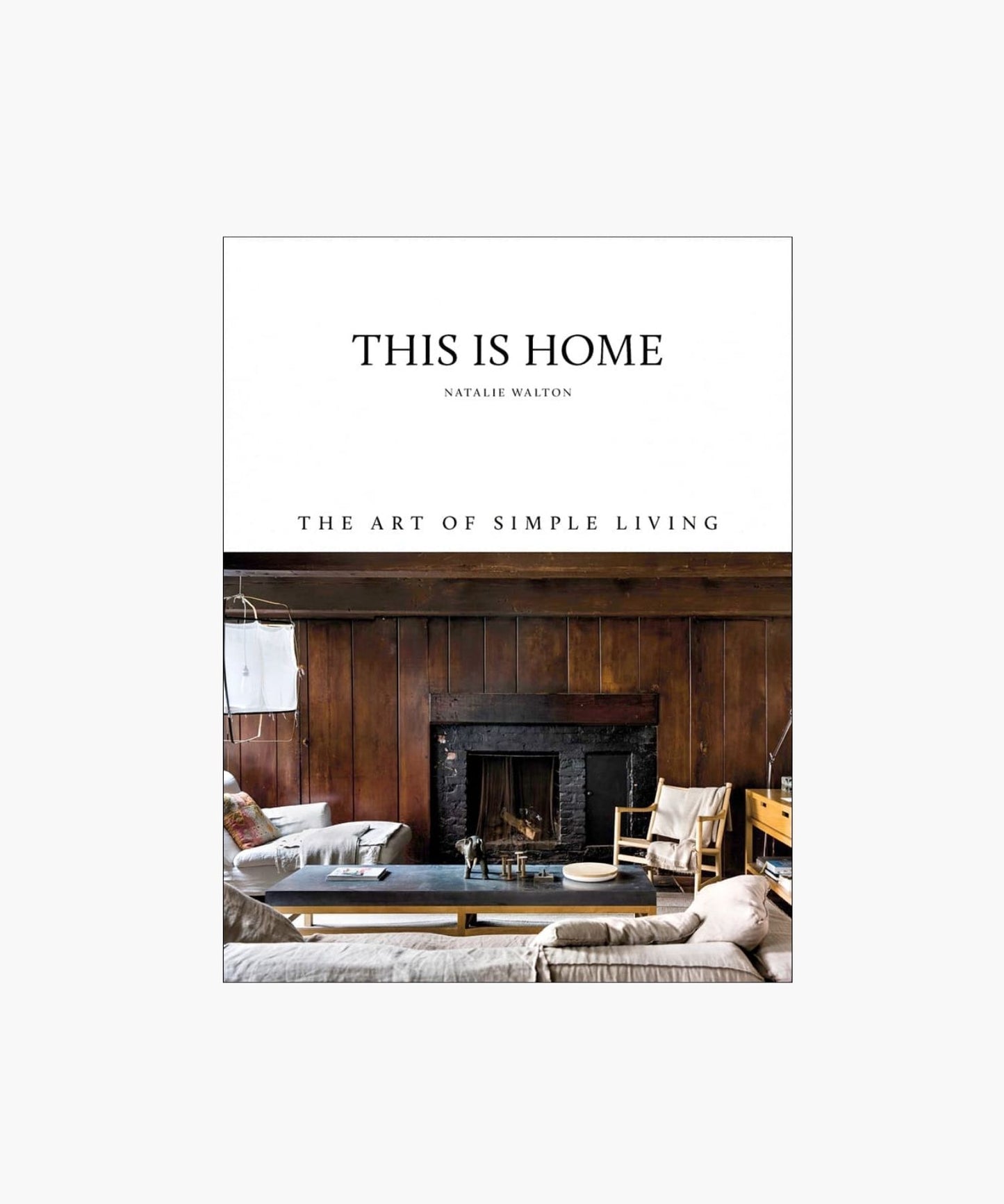 Cover of the book "This Is Home" by Natalie Walton, featuring a rustic, cozy living room with wooden walls, a fireplace, seating, and a coffee table.