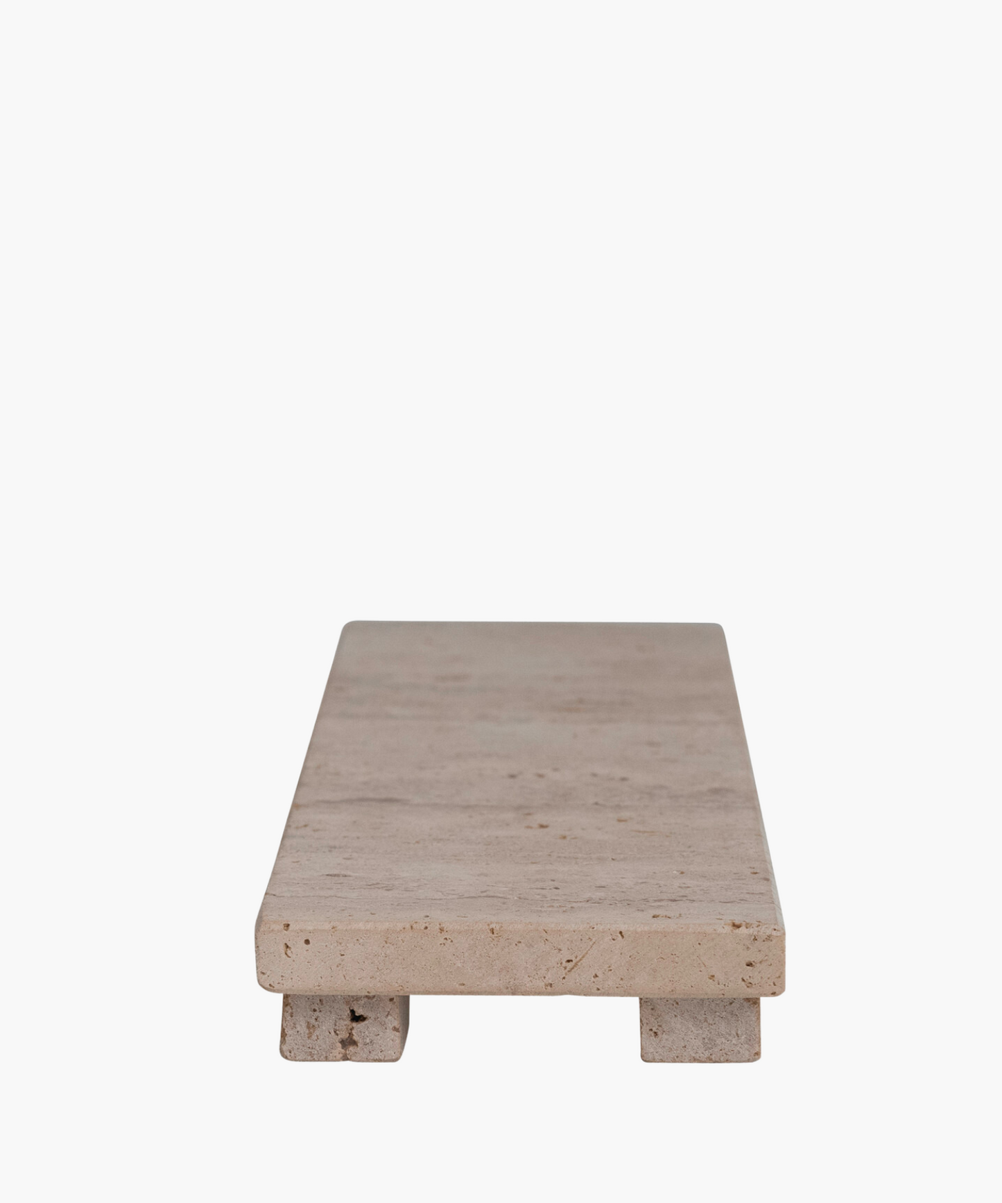 Rectangular travertine tray with a smooth, beige surface, elevated on two block legs. The minimalist design gives a clean, modern aesthetic.