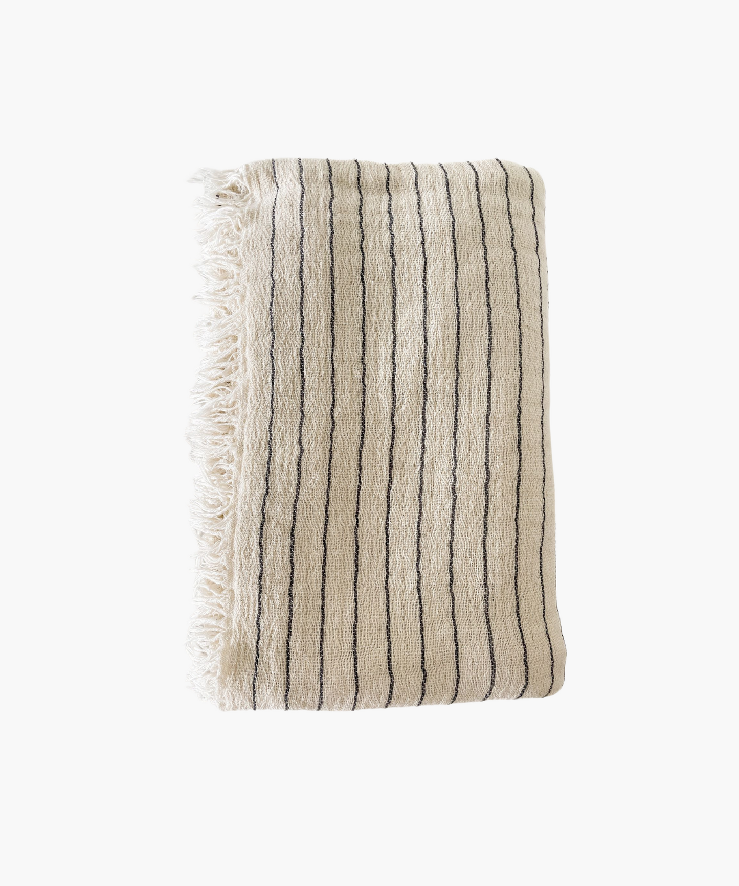 A folded beige throw blanket with thin black stripes and fringed edges. The fabric appears textured and soft, evoking a sense of warmth and comfort.