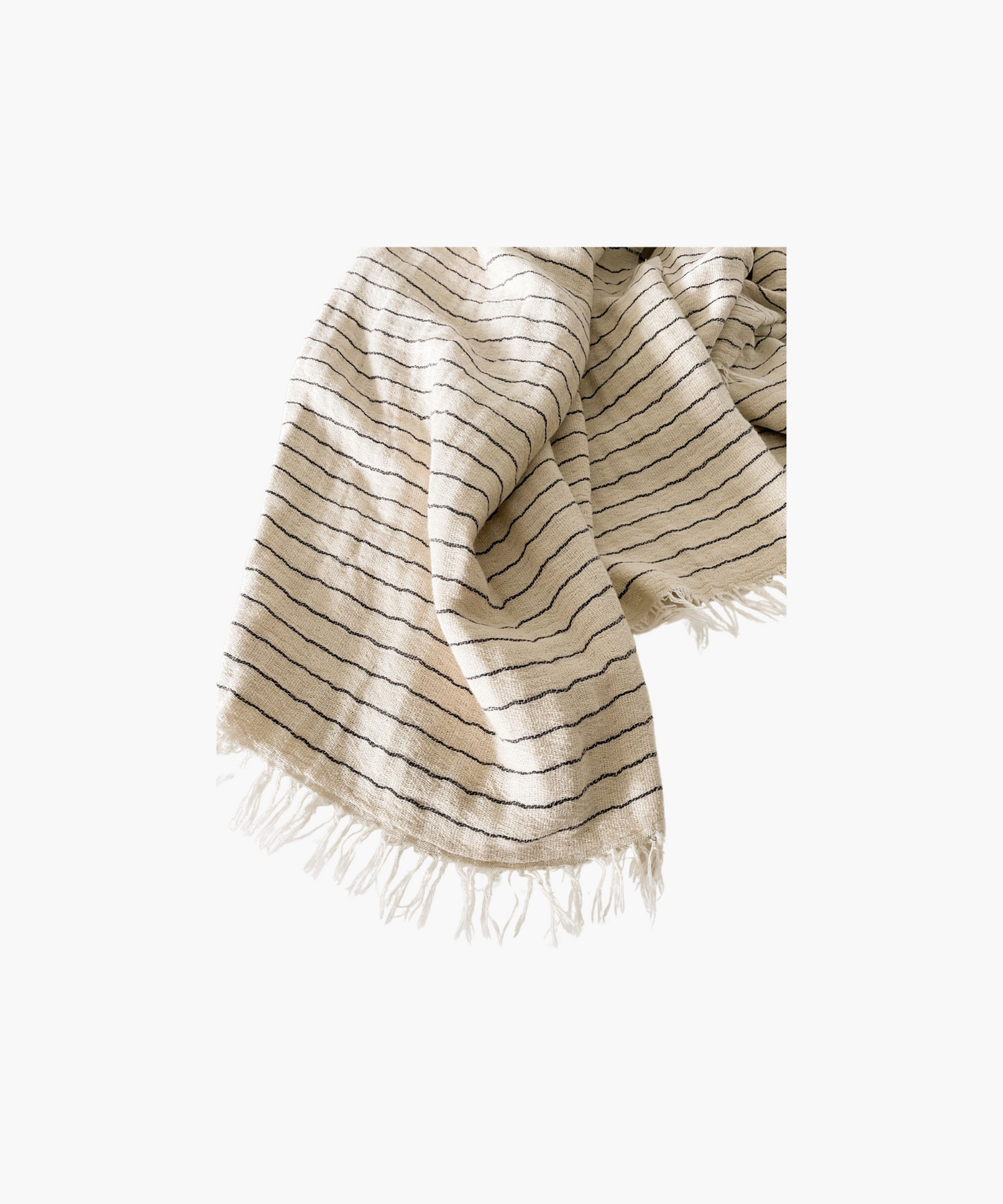 A folded beige throw blanket with thin black stripes and fringed edges. The fabric appears textured and soft, evoking a sense of warmth and comfort.