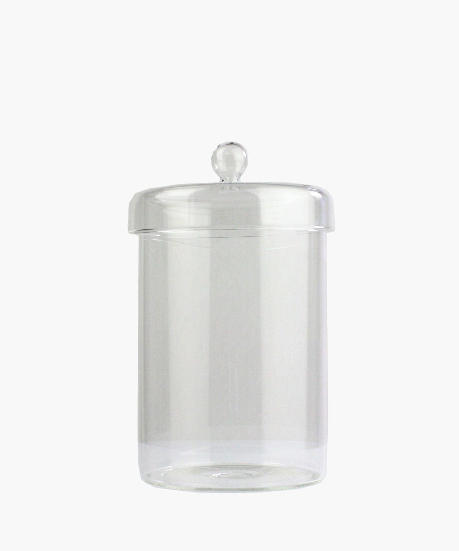 A clear glass jar with a round lid and a knob handle is centered on a plain white background. The jar is empty, conveying simplicity and elegance.