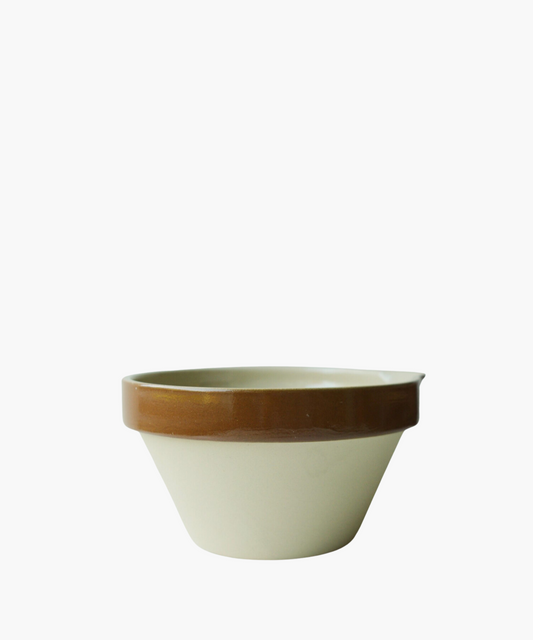A ceramic bowl with a beige base and a glossy brown rim. The simple and functional design conveys a rustic and practical tone.