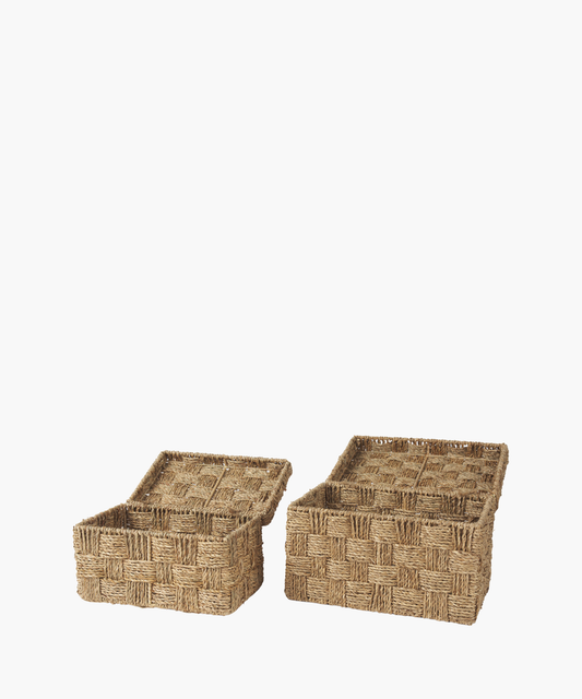 Two open woven baskets made of natural fiber with lids lie against a plain background, displaying a checkered pattern. The tone is earthy and rustic.