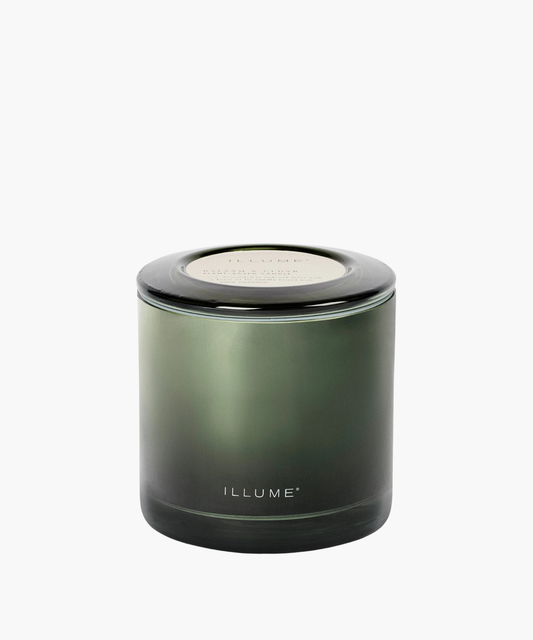 A sleek, green glass candle jar labeled "ILLUME" with a subtle gradient effect. The overall design is minimalist, highlighting a calm and elegant tone.