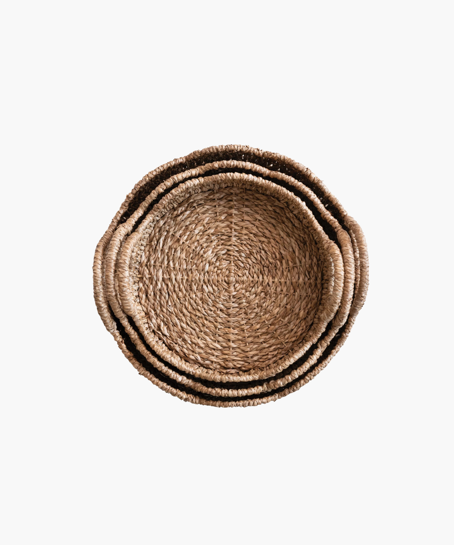 An overhead picture of three woven, round baskets with scalloped edges and two looped handles. Made of natural fibers, it evokes a rustic and earthy aesthetic.