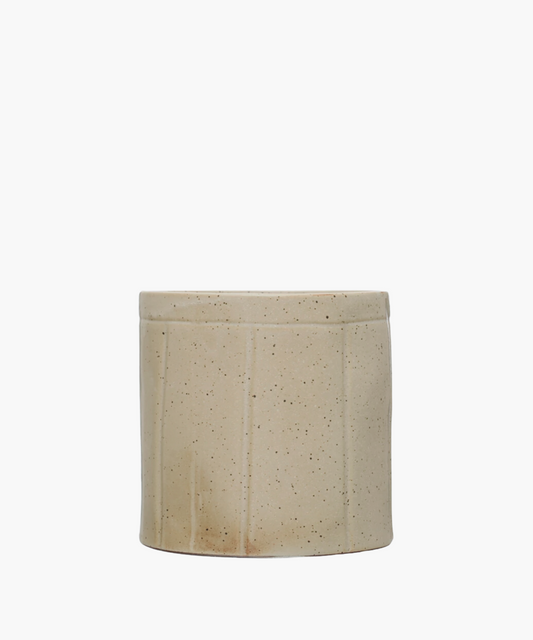 Simple beige ceramic crock with vertical grooves and dark speckles. The crock conveys a minimalist, rustic aesthetic suitable for home decor.