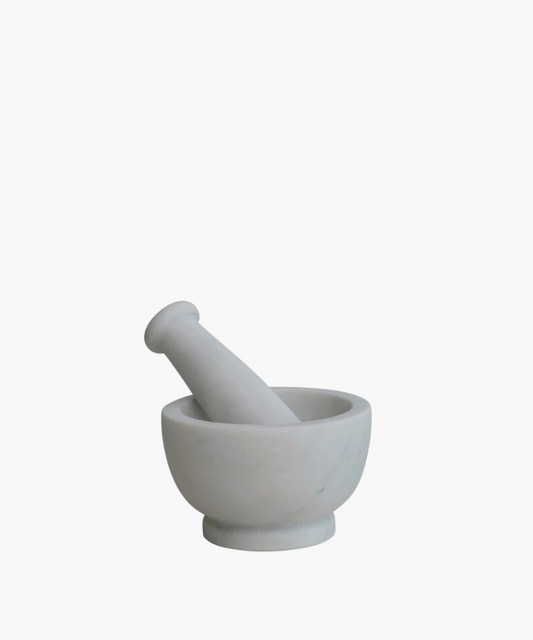 A white marble mortar and pestle set on a plain background. The smooth, round design conveys a sense of elegance and simplicity, ideal for grinding.