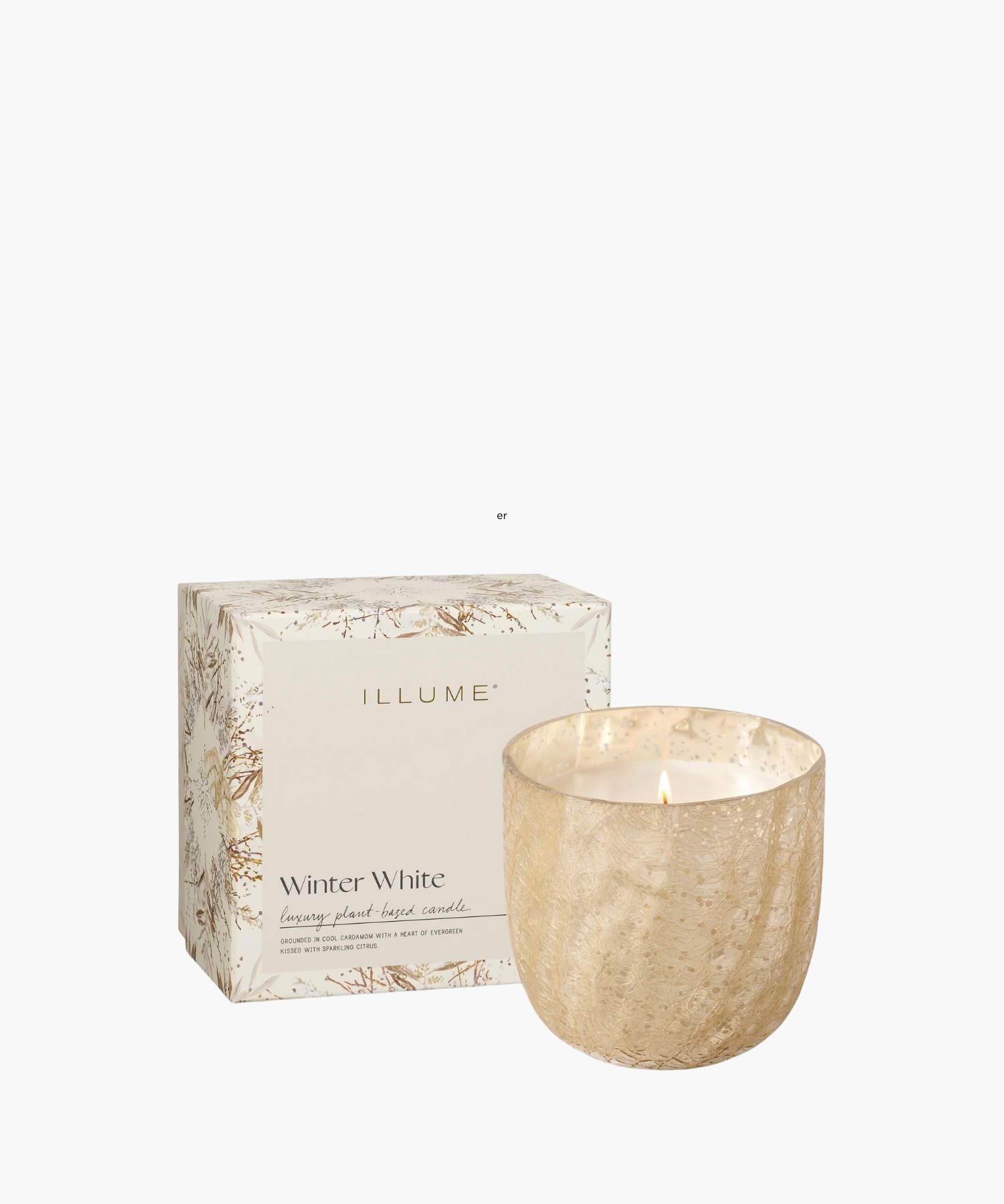 A lit candle in a textured, gold holder next to a decorative box labeled "Winter White" by Illume. The scene conveys warmth and elegance.